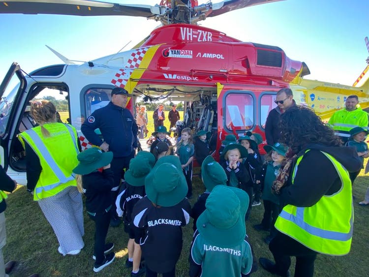 May be an image of 5 people, helicopter, ambulance and text that says 'VH-ZXR YANCOALAMPOL YANCOAL YANCOAL ٨ AMPOL ስስሥ WMestpic LM estp: LSHING Lm BLACKSN ACKSy BL BLACKSMIT'S BLACKSMITHS'